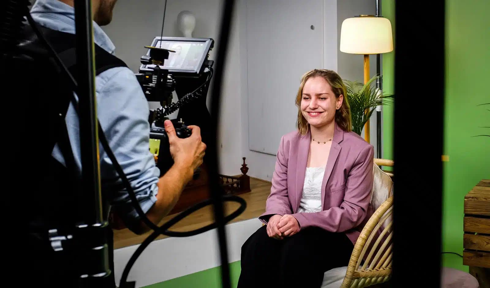 Woman being filmed for a professional video interview in a studio setting.