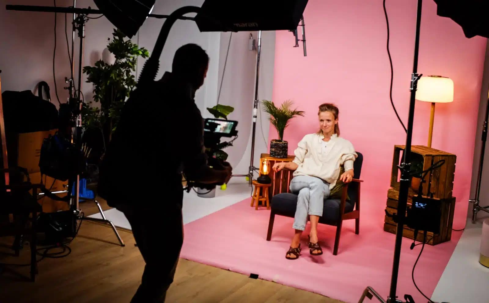 Professional video shoot with a woman seated in a studio setting.