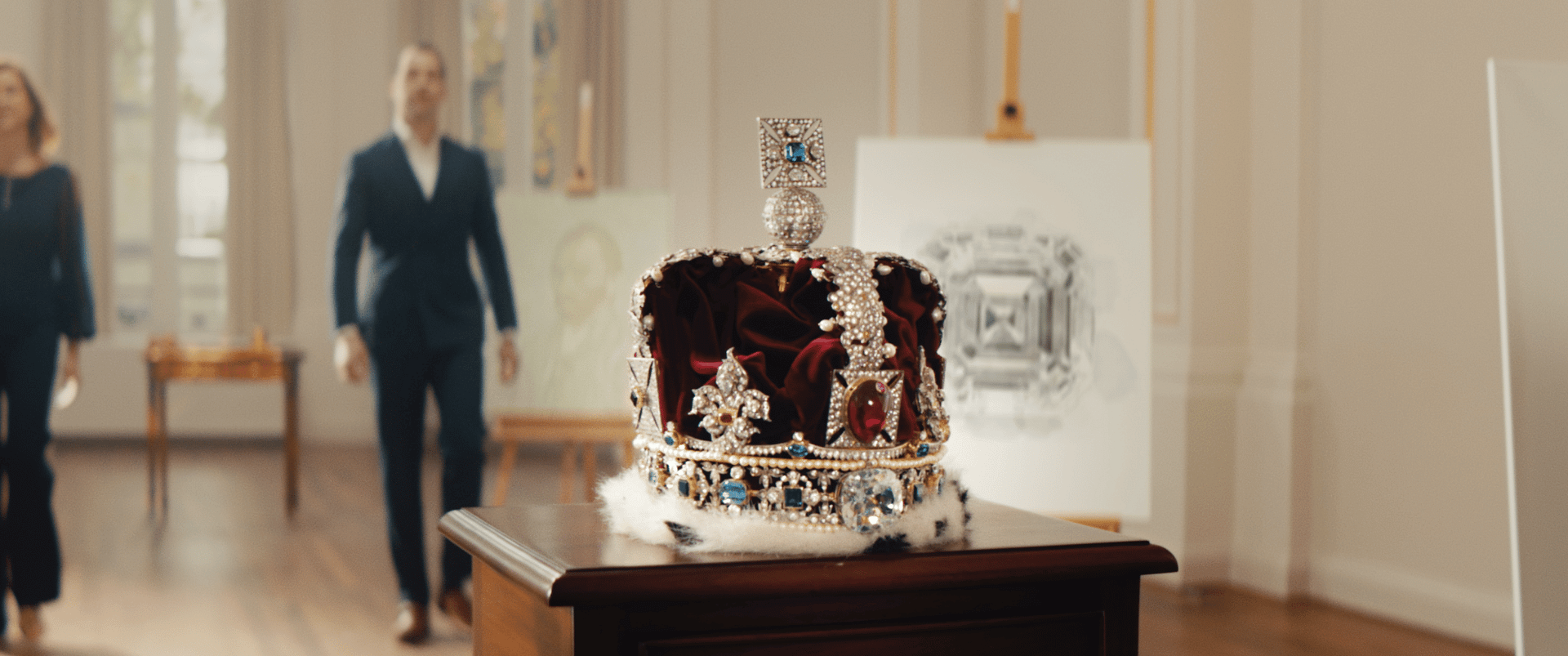 Elegant royal crown displayed in an art gallery setting.