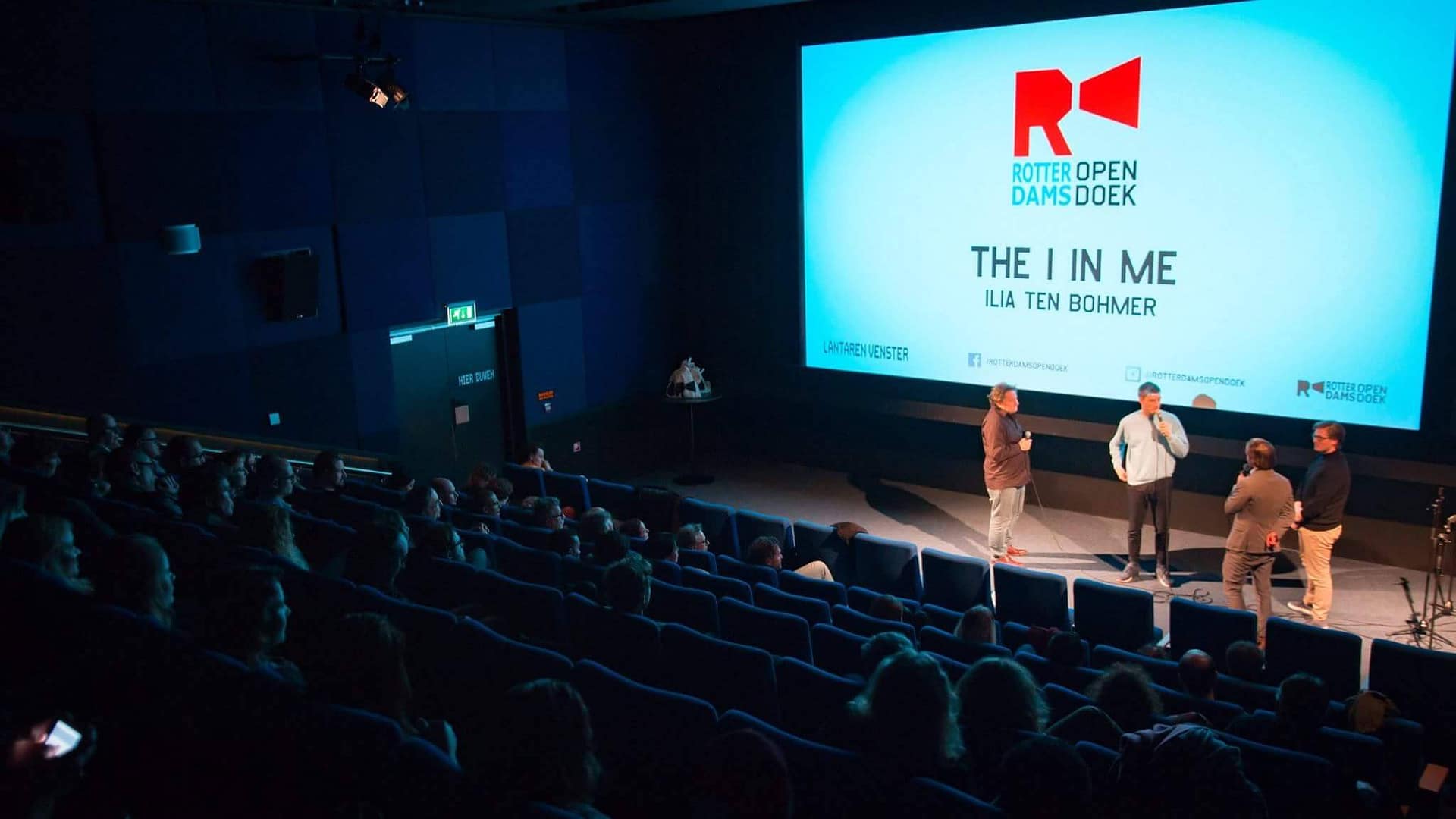 Creative video agency event with speakers on stage and audience in theater setting.
