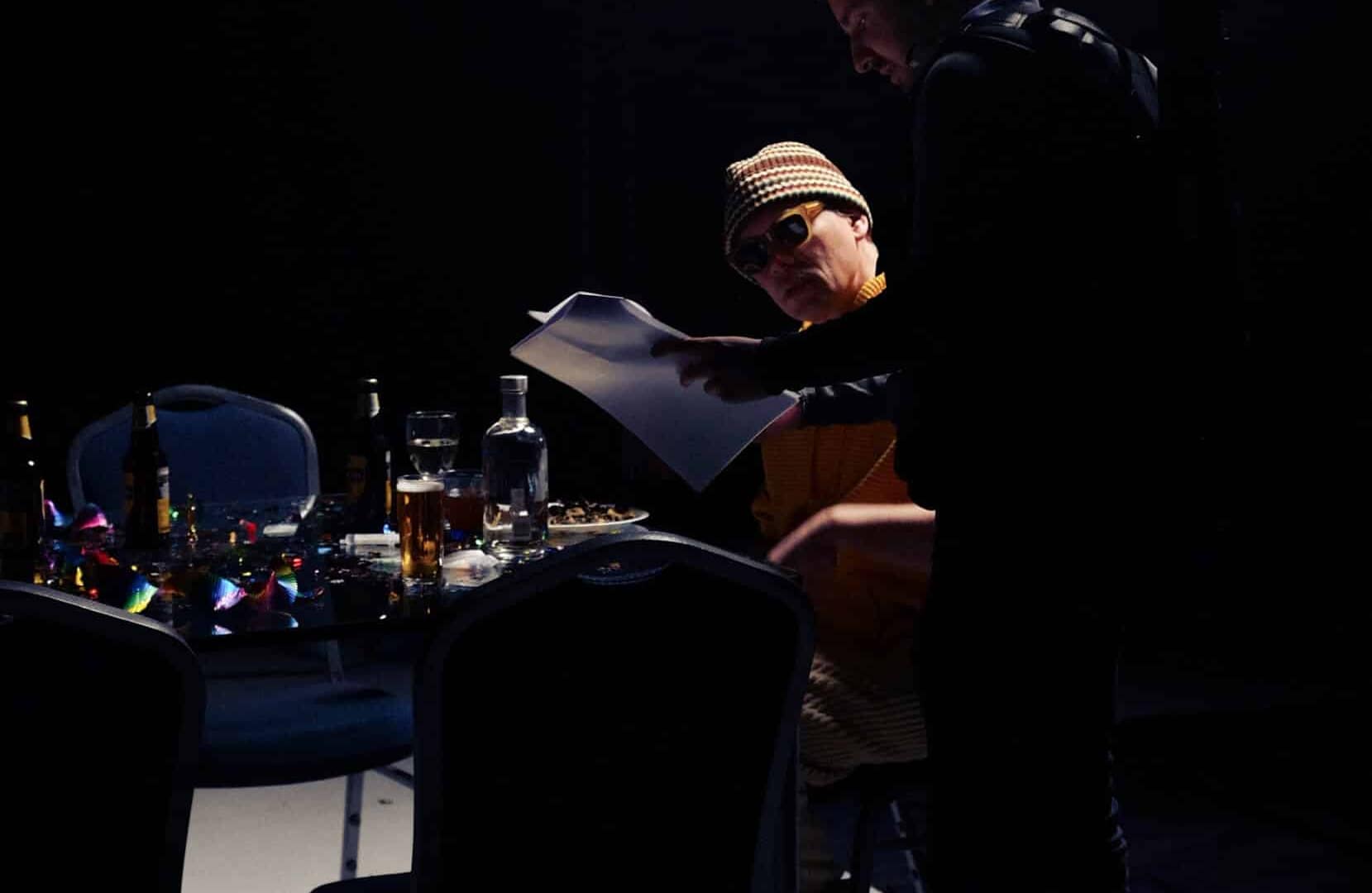 Two people collaborating on a creative video project in a dark studio.