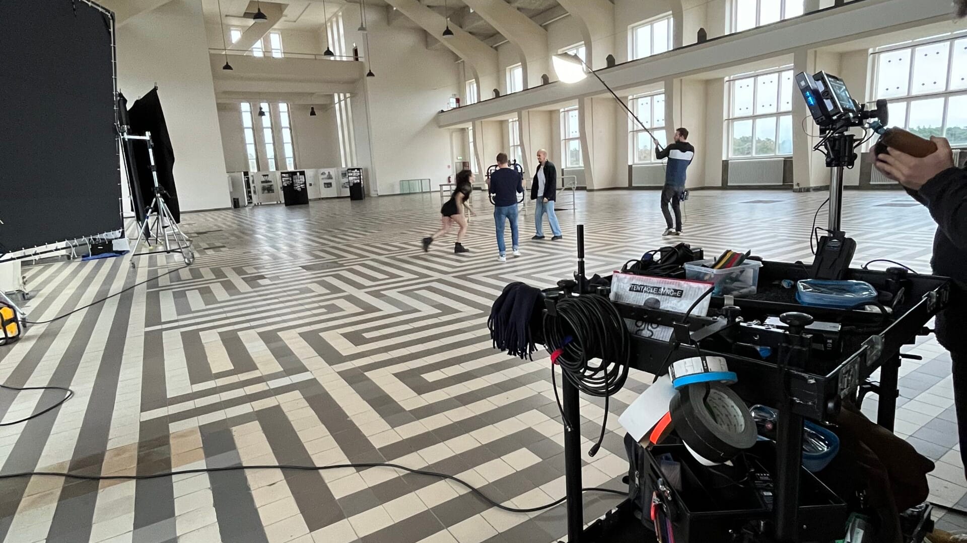 Professional video shoot in a large, well-lit studio with crew and equipment ready.