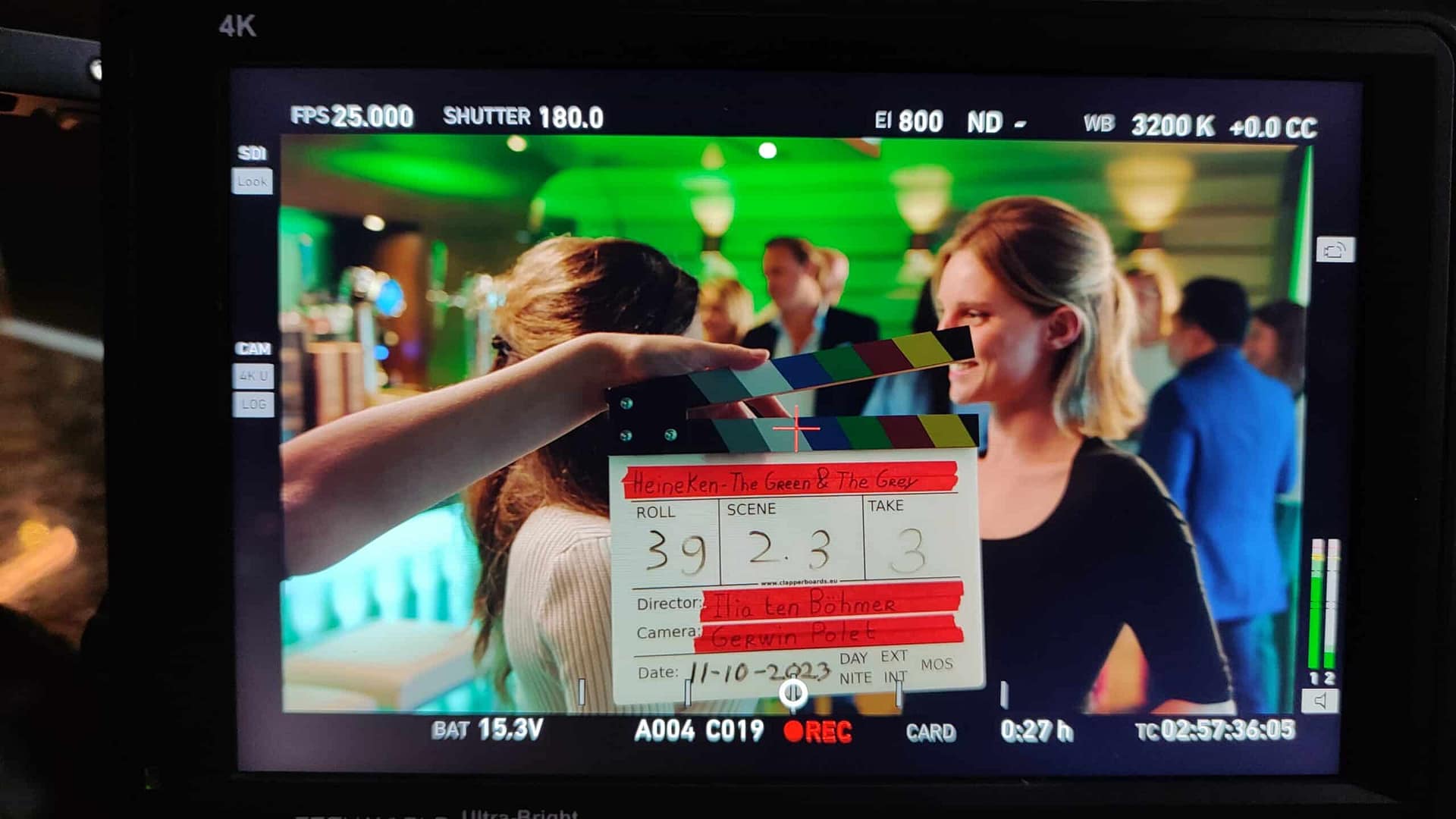 Behind-the-scenes shot of a creative video shoot with a clapperboard and crew.