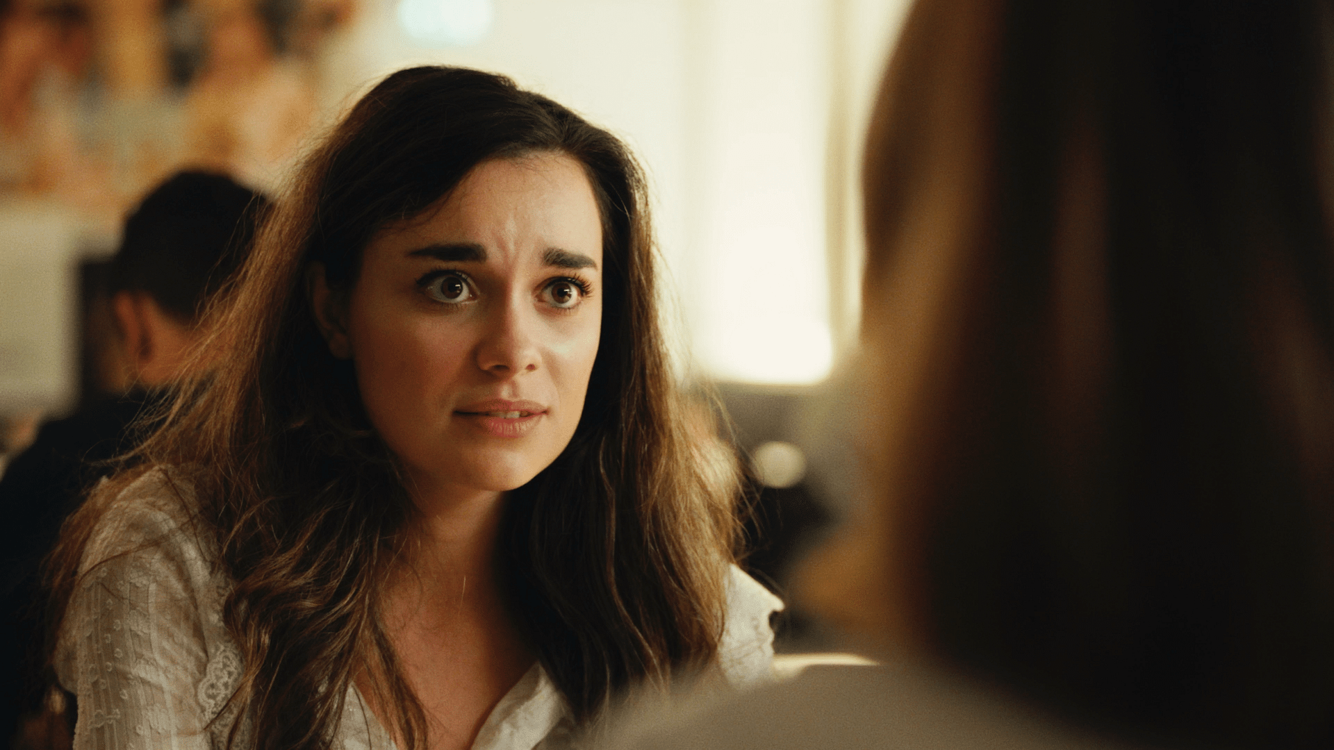 Woman with concerned expression during a video shoot or meeting.