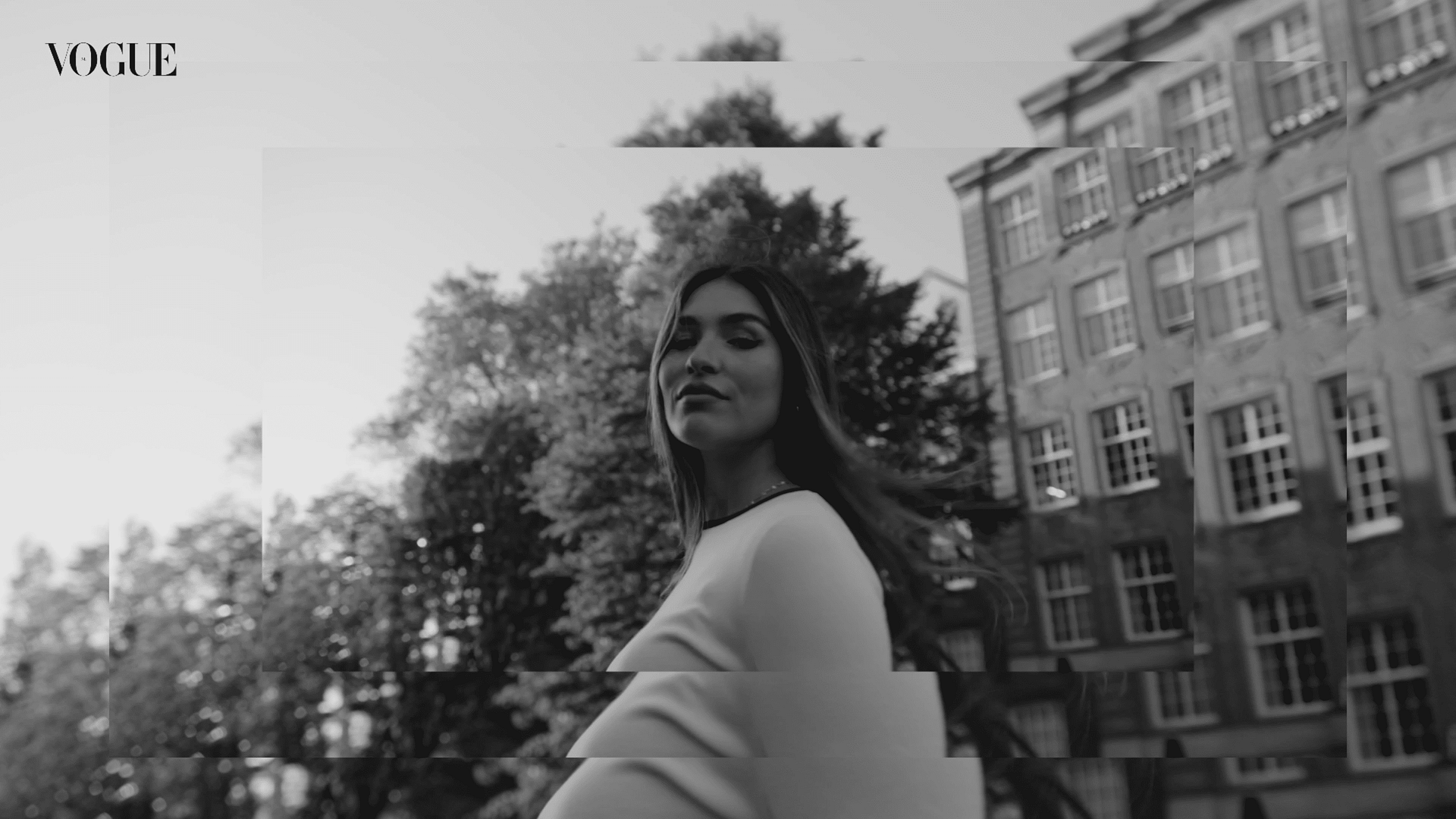 Modern woman outdoors with city buildings, representing creative video production.
