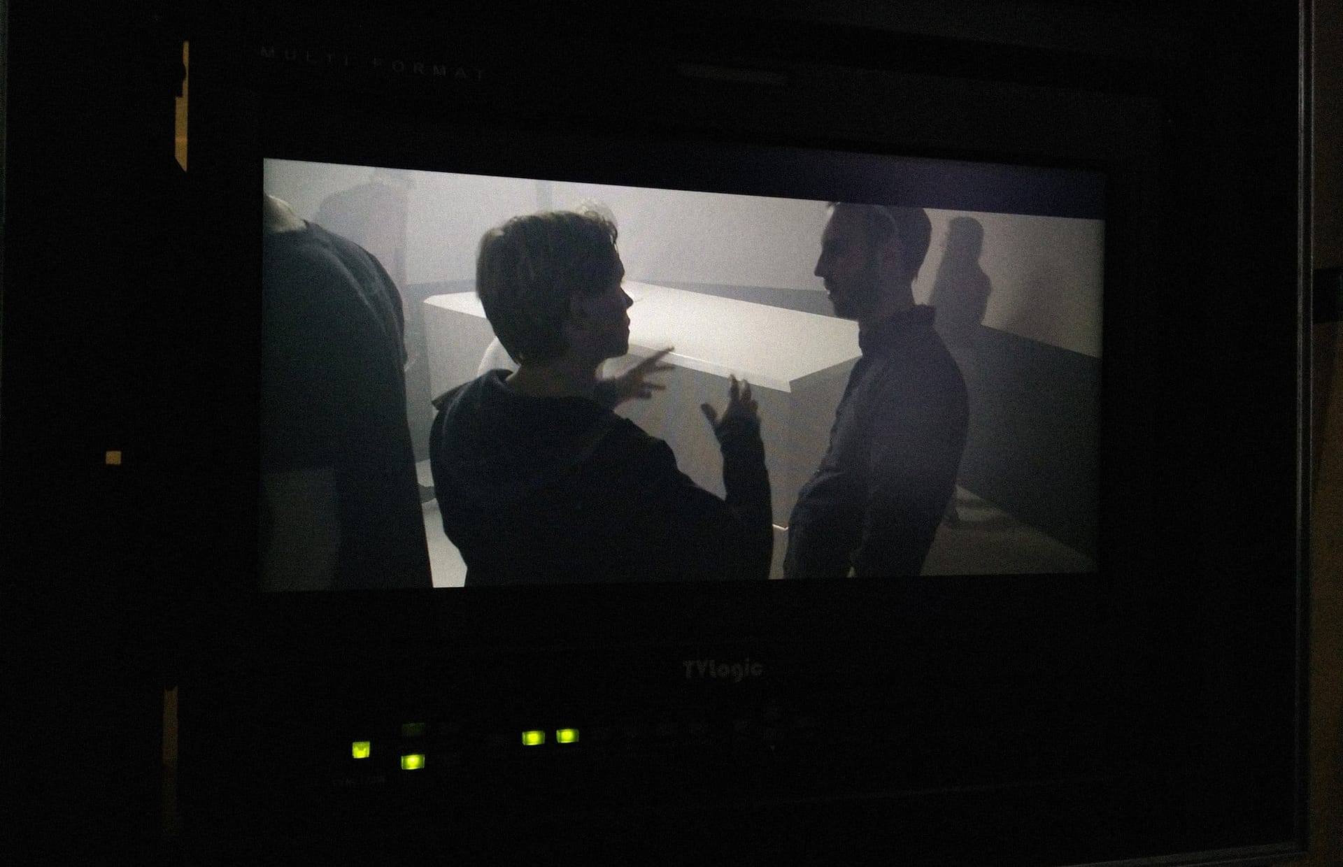 Two people discussing in a dark room, creating video content.