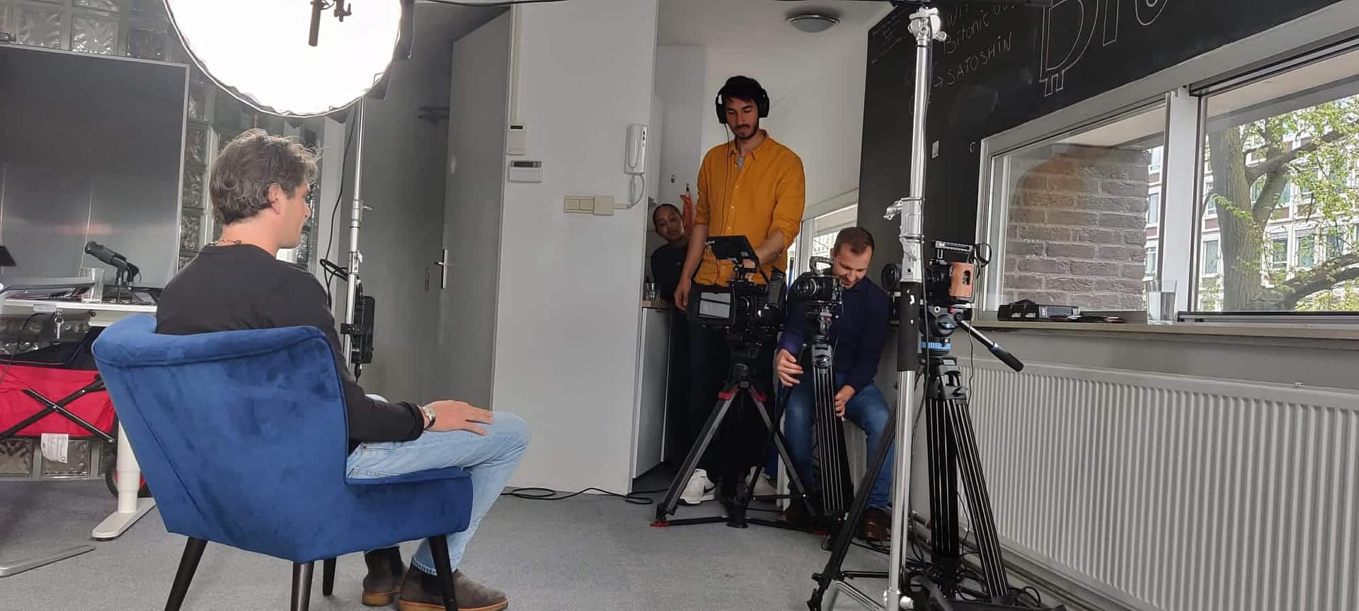 Interview setup with crew filming a professional interview indoors.