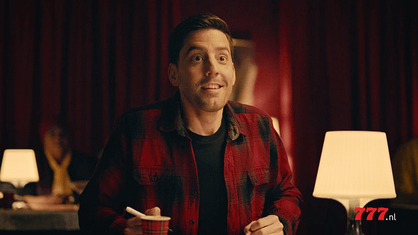 Image of a cheerful man at Casino 777, engaging in a lively conversation in a warm, inviting environ.