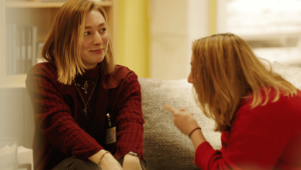 Two women having a conversation in a cozy indoor setting.
