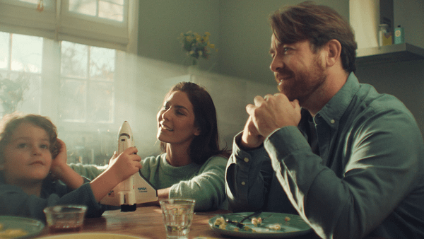 Family enjoying a creative activity with a toy rocket in a cozy home setting.