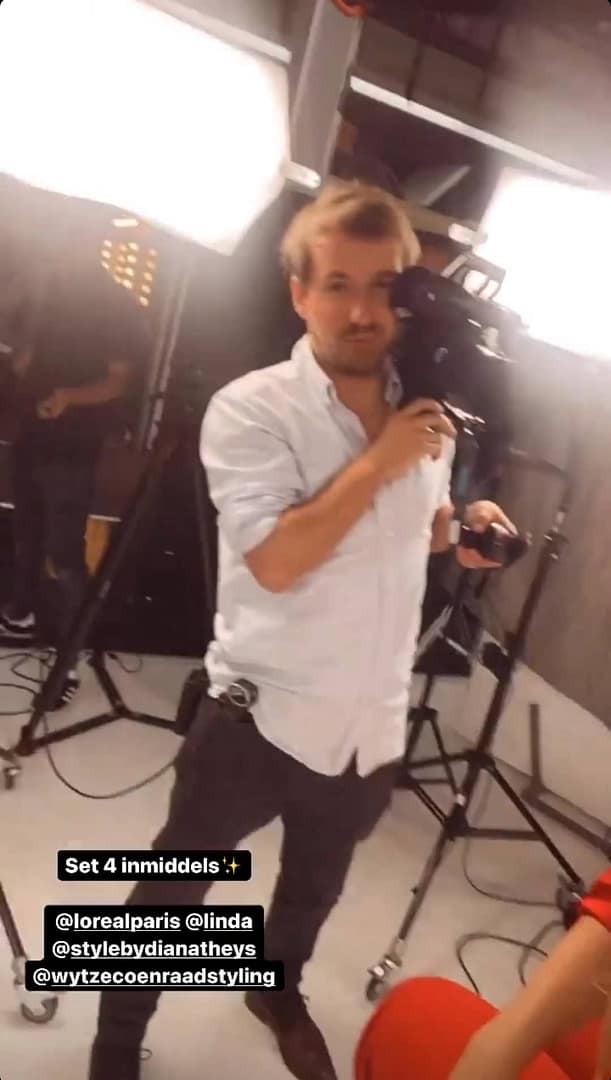 Behind-the-scenes shot of a videographer filming in a studio setting.