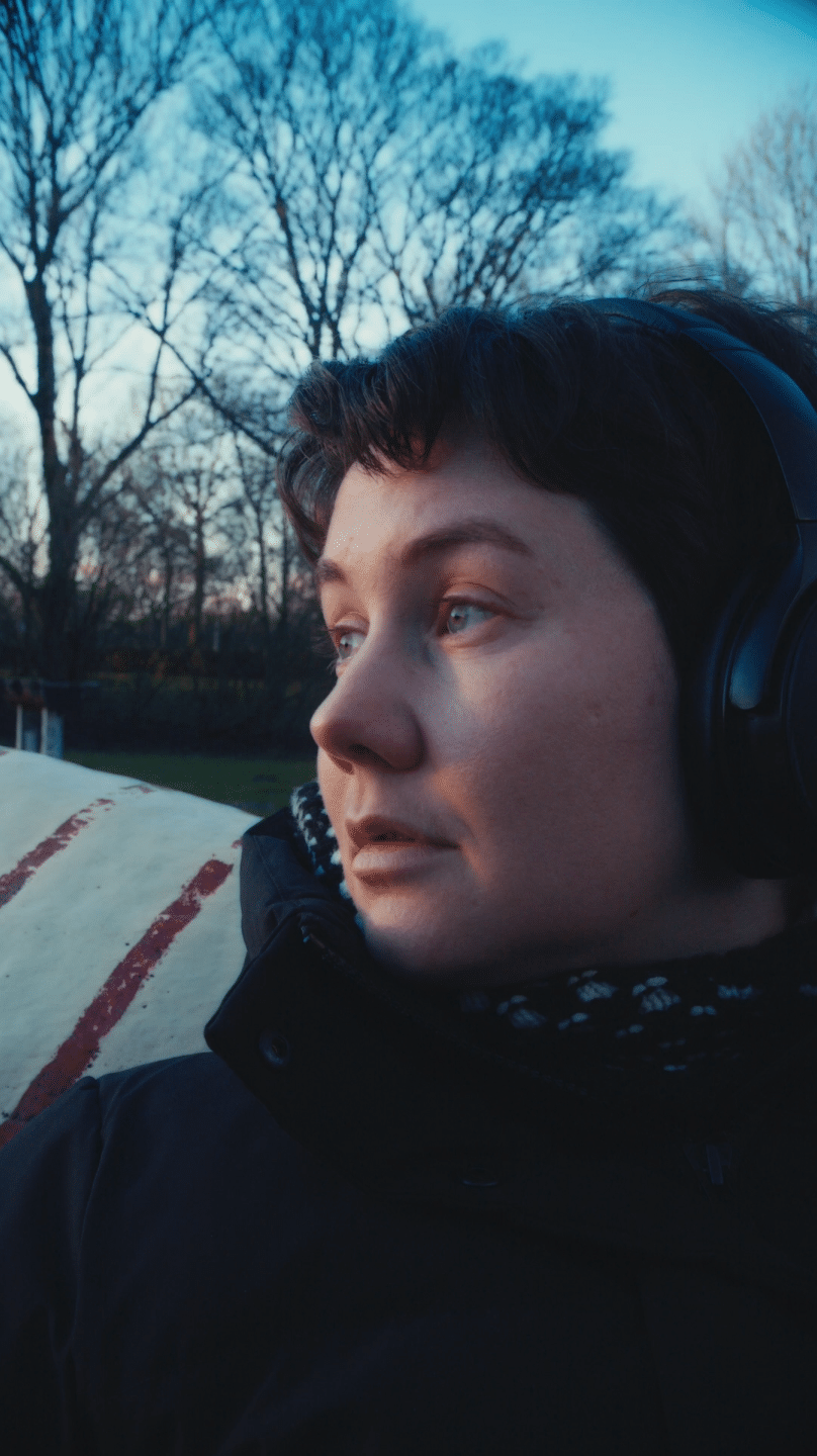 Woman with headphones outdoors, representing creative video production.