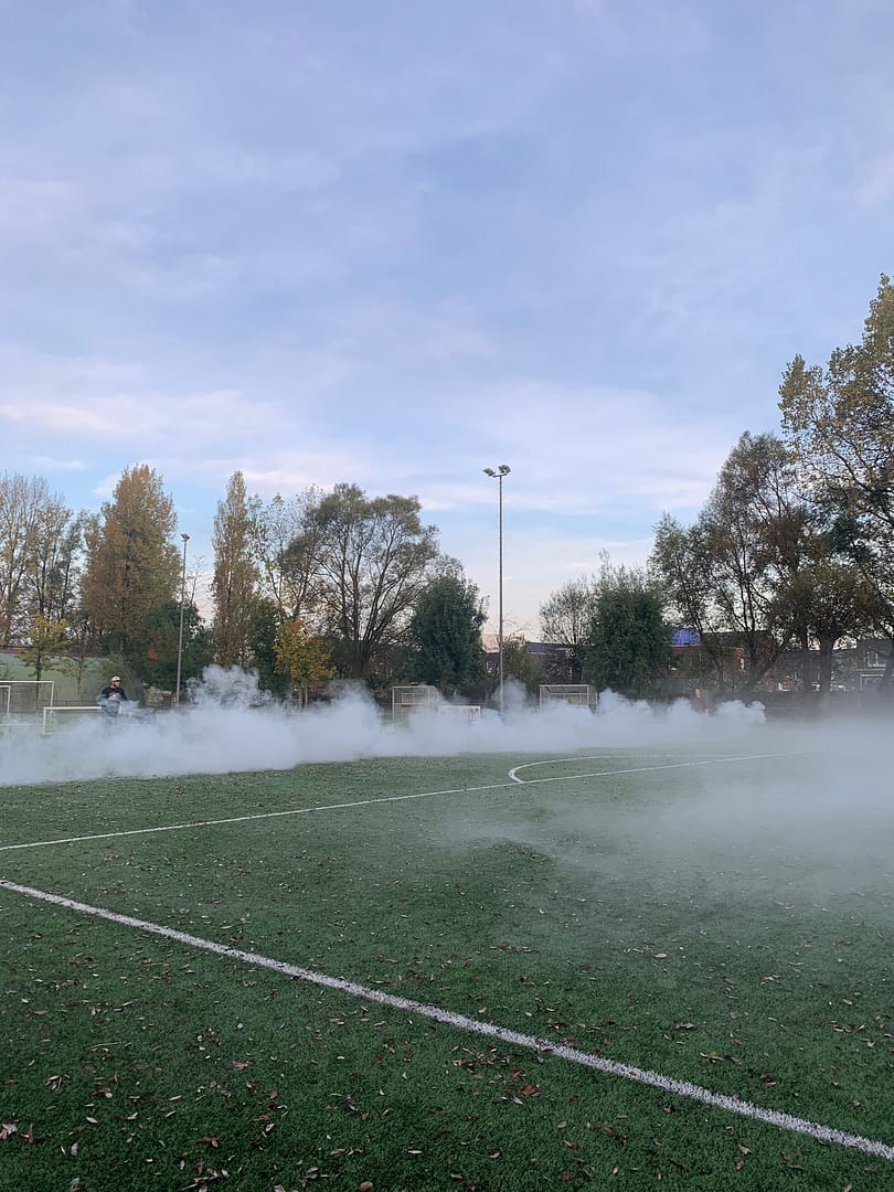 Smoke on a sports field during daytime.