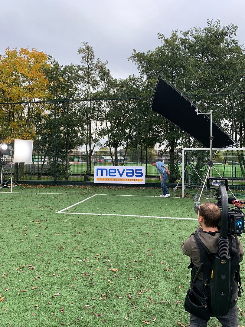 Outdoor filming setup with professional lighting and camera gear on a sports field for video product.