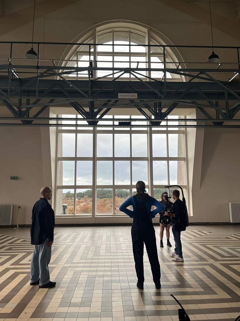 Bright spacious room with high ceiling, large window, and industrial design elements.