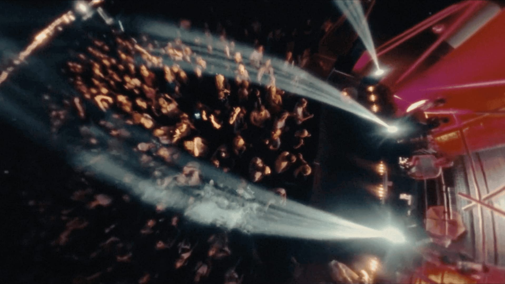 Dynamic concert scene with colorful lights and enthusiastic audience engagement.